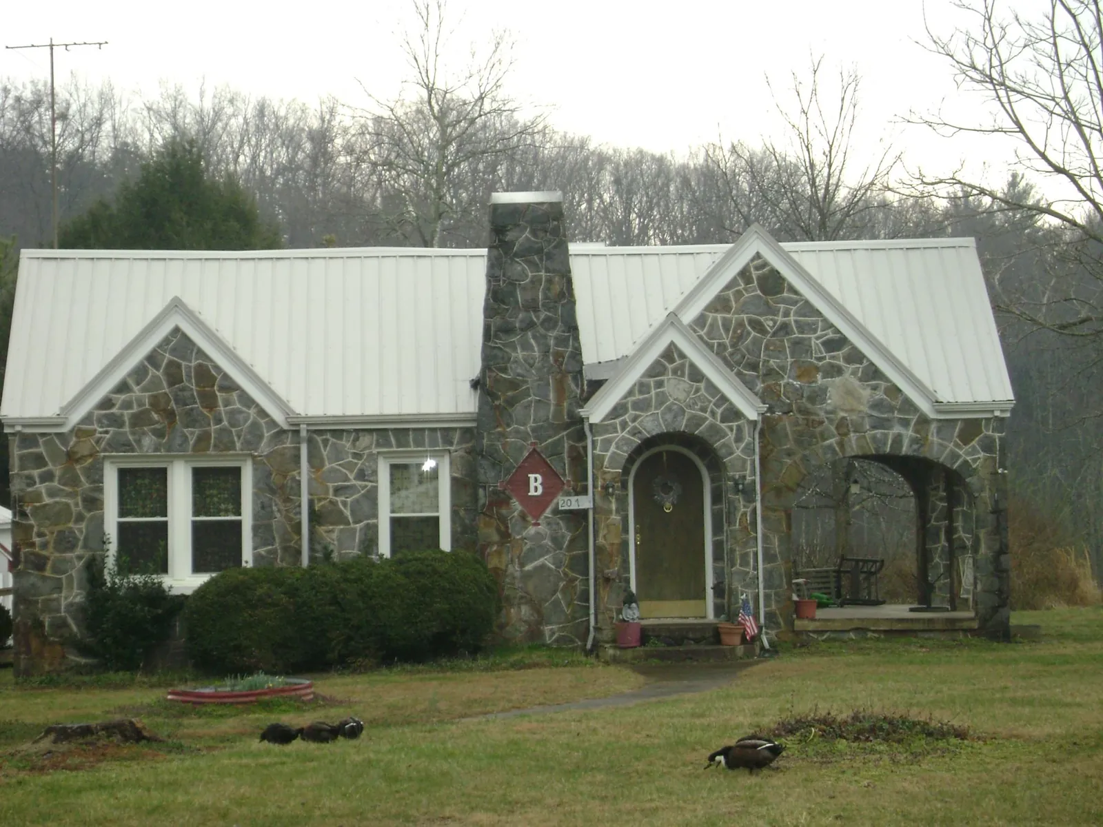 White metal roof on a stone cottage with steep gables in Middleburg